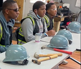 Young participants learning with hard hats and tools